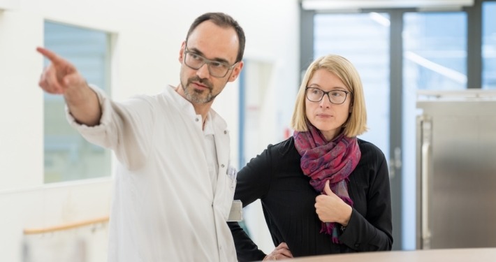 Ein Arzt zeigt nach links während er mit Christina Haberlander spricht